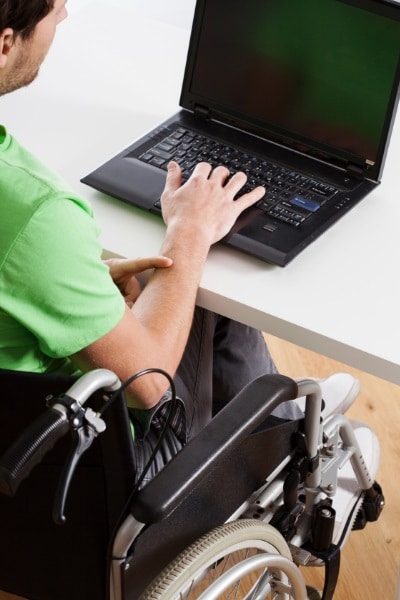 disability discrimination - man in a wheelchair at computer